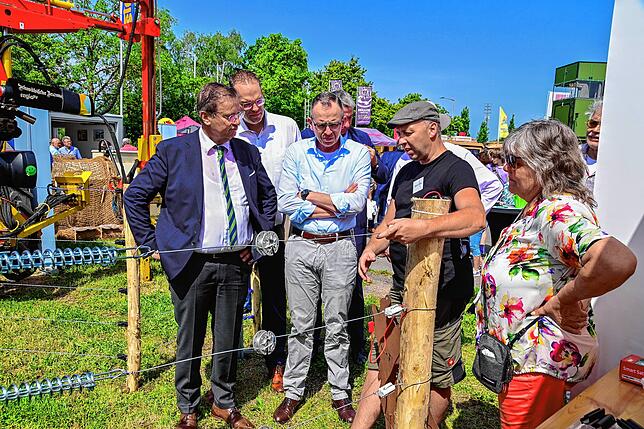 Markus Haas (Zweiter von rechts) erläutert den Ehrengästen die Funktion des Herdenschutzzaunes. Da hört Landwirtschaftsminister Peter ...