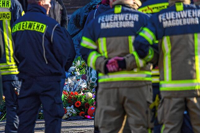 Feuerwehrmänner der Magdeburger Feuerwehr stehen vor der Johanniskirche.