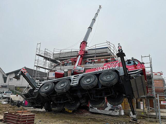 In Wahlen (Kanton Basel-Landschaft) kippt ein Autokran auf einen Rohbau. Fast alle Räder in der Luft, der Aufleger auf dem Gebäude.