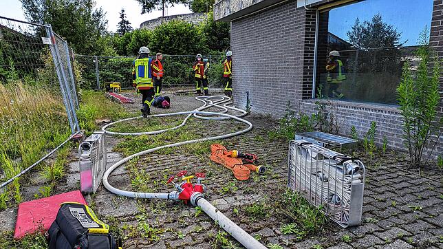 Ein Schlauch führt in den Keller, wo ein Brandherd vermutet wird.