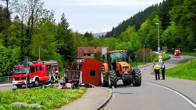 Rettungskräfte stehen nach einem Unfall in Kandern neben einem umgestürzten Maiwagen.