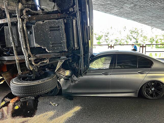 Das Auto steckt bis zur Windschutzscheibe unter dem Lastwagen.