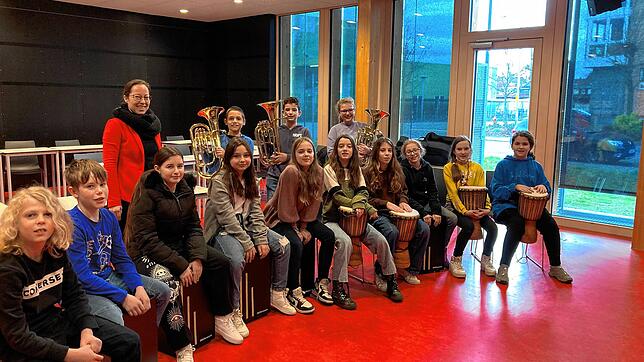 Schülerinnen und Schüler des Teams 5 Grün freuen sich mit ihrer Musiklehrerin Susanne Pantel (hinten) über die neuen Instrumente und ...