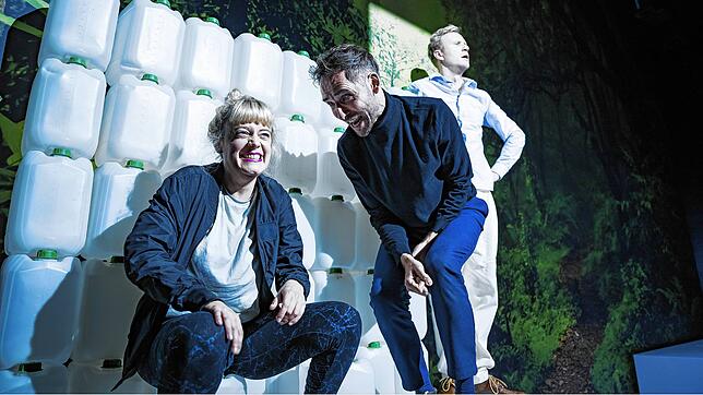 Schmitz (Sarah Siri Lee König, links) und Eisenring (Jonas Pätzold, Mitte) feixen über die Naivität ihres Gastgebers, Gottlieb ...