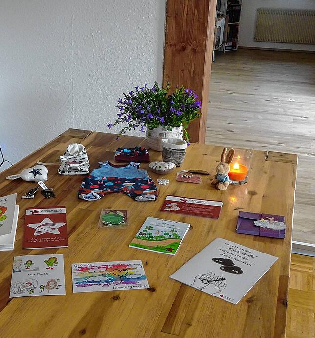 An ihrem Esstisch, gemütlich mit Kerzenlicht, schneidet Alexandra Krüger oft abends Decken, Strampler und Mützen für die Allerkleinsten zu.
