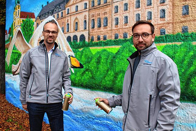 Thomas Sauter und Tobias Hall von ED Netze sind begeistert von Torben Störmers Wandbild in der Donaueschinger Poststraße.