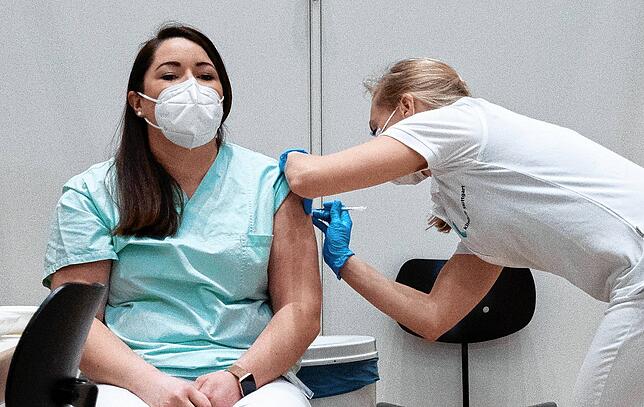 Die Stuttgarter Pflegerin Christine Helbig (l), ist eine der ersten Personen, die in Baden-Württemberg gegen das Coronavirus geimpft wurden.