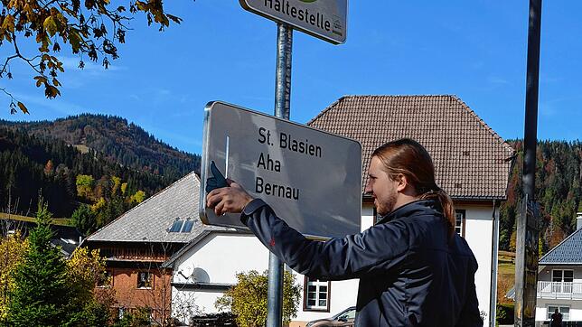 An der Mitfahrerhaltestelle gibt man an einem Schild an, in welche Richtung man gerne mitfahren möchte.