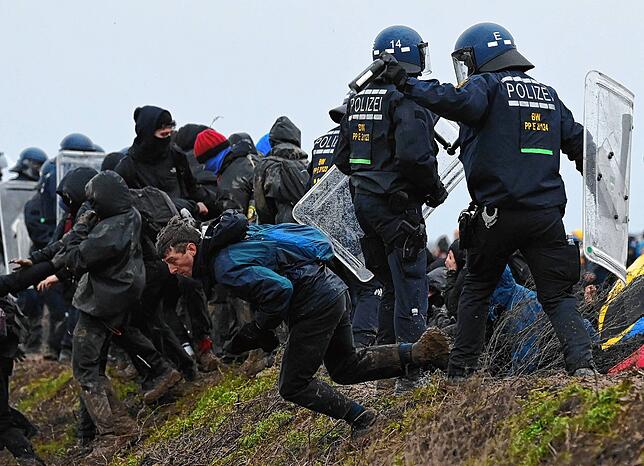 Ein Demonstrant durchbricht eine Polizeibarriere in der Nähe von Lützerath.