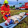 Vor dem Abtransport beobachtet ein Sanitäter den verletzten Autofahrer. Der Fahrer erlitt durch den Aufprall ein Schädelhirntrauma, so ...