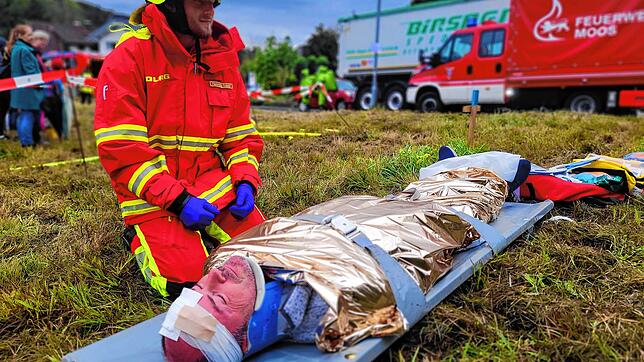 Vor dem Abtransport beobachtet ein Sanitäter den verletzten Autofahrer. Der Fahrer erlitt durch den Aufprall ein Schädelhirntrauma, so ...
