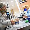 Eine Kundin mit Mund-Nasen-Schutz in einem Supermarkt packt ihre Einkäufe ein. Dass das Tragen der Maske zur Immunisierung gegen das ...