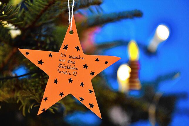 &bdquo;Ich wünsche mir eine glückliche Familie&ldquo; steht auf einem Stern, der an einem Weihnachtsbaum hängt. Bei vielen Familien wird ...
