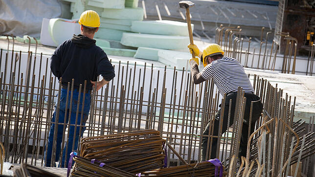 Zwei Männer arbeiten auf einer Baustelle. Derzeit schwächt sich das Wirtschaftswachstum in Deutschland ab. Trotzdem lehnt der ...