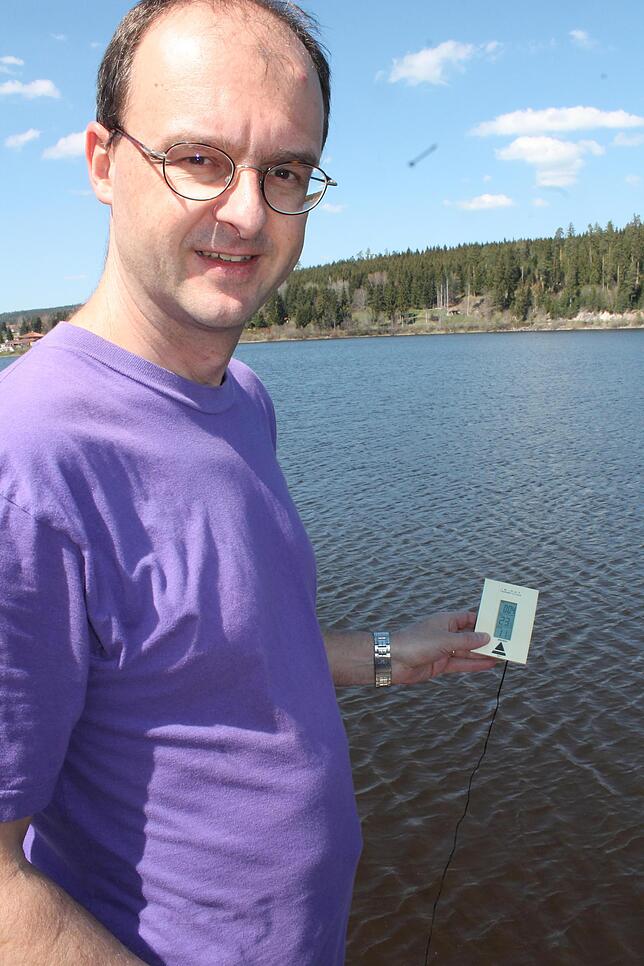 Thomas Moch, Vorsitzender der DLRG-Ortsgruppe Baar, misst die Wasser- und Außentemperatur am Kirnbergsee.