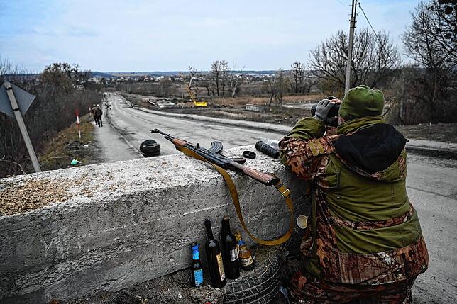 Ein ukrainischer Soldat blickt am 6. März an einem Kontrollpunkt vor der letzten Brücke, die Stojanka mit Kiew verbindet, durch ein ...