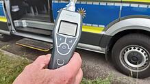 Ein Polizist hält einen Alcomaten in der Hand. (Symbolbild) Die Polizei hat in Birkendorf einen 35-Jährigen kontrolliert, der auch noch ...