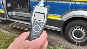 Ein Polizist hält einen Alcomaten in der Hand. (Symbolbild) Die Polizei hat in Birkendorf einen 35-Jährigen kontrolliert, der auch noch ...