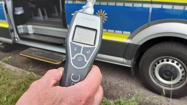 Ein Polizist hält einen Alcomaten in der Hand. (Symbolbild) Die Polizei hat in Birkendorf einen 35-Jährigen kontrolliert, der auch noch ...