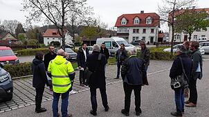 Der Gemeinderat mit Bürgermeister Denis Lehmann diskutiert auf dem Parkplatz Sennerei Schläge über den Neubau eines kleinen Busbahnhofs.