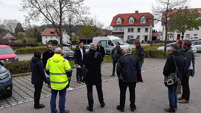 Der Gemeinderat mit Bürgermeister Denis Lehmann diskutiert auf dem Parkplatz Sennerei Schläge über den Neubau eines kleinen Busbahnhofs.