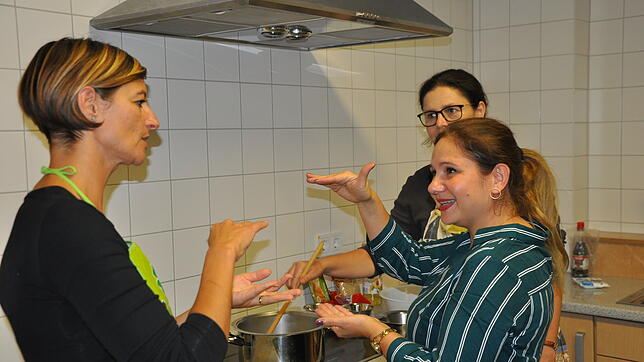 Loredana Schaz, Nalan Kandemir und Andrea Braun-Henle (von links) unterhalten sich angeregt über die Zubereitung einer roten Linsensuppe.