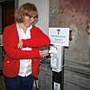 Barbara Koch vom Sekretariat der Wallfahrtskirche Birnau demonstriert, wie man mit Ellenbogen den Weihwasser-Spender bedient.