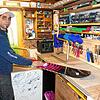 Leo Aita bereitet in seiner Werkstatt ein Snowboard vor, um es zu einer Sitzgelegenheit weiterverarbeiten zu können.