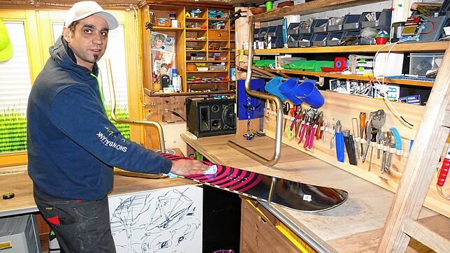 Leo Aita bereitet in seiner Werkstatt ein Snowboard vor, um es zu einer Sitzgelegenheit weiterverarbeiten zu können.