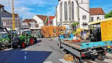 Wirkt wie ein Baustellen-Dorf. Die Hütten und Lauben für das Stadtfest werden aufgebaut. Mehrere Traktoren und Anhänger werden dafür ...