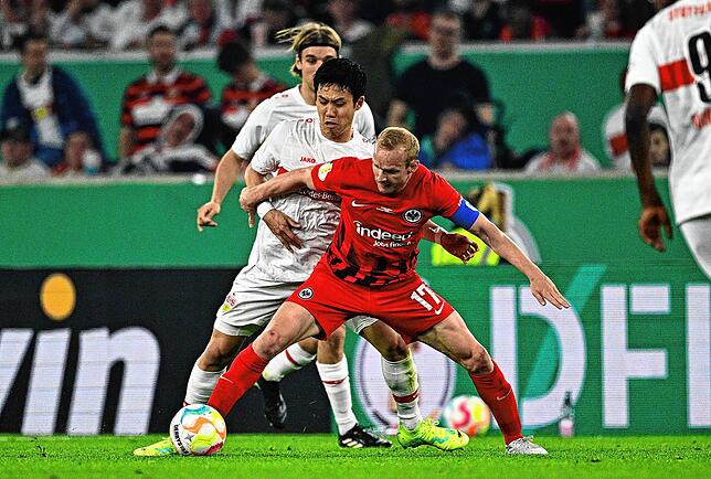 Stuttgarts Wataru Endo (l) und Frankfurts Sebastian Rode kämpfen um den Ball.