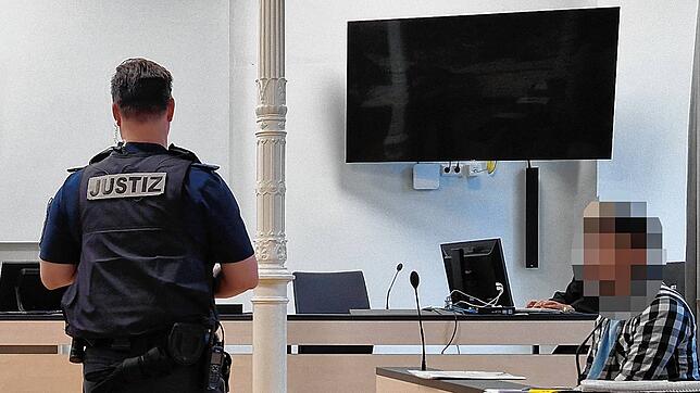 Der 33-Jährige auf der Anklagebank. Ein Justizbeamter hat sich im Gerichtssaal vor ihm positioniert.