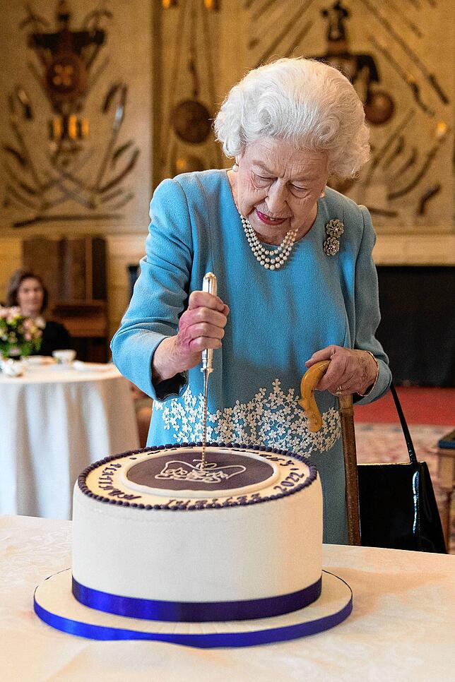 Königin Elizabeth II. schneidet zum Beginn der Feierlichkeiten ihres 70. Thronjubiläums einen Kuchen an.