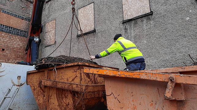 Florian Mauch steuert das Metallrad mit dem Nestrest in einen Container auf dem Kranfahrzeug.