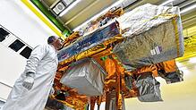 Ein Techniker kontrolliert in einer Montagehalle von Airbus Defence And Space in Immenstaad den im Bau befindlichen Satelliten MetOp-C.