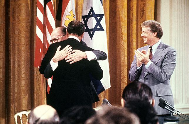 (FILES) Egyptian President Anwar al-Sadat (back to camera) and Israeli Premier Menachem Begin embrace each other, on September 17, 1978, ...