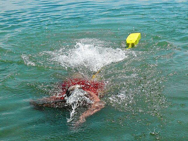 Rettungsschwimmerin Sybille Rinn zeigt, wie man mit einem Gurtretter sich einem erschöpften Schwimmer nähert.