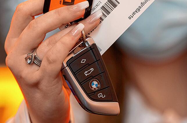 Eine Mitarbeiterin des Autovermieters Sixt hält einen Autoschlüssel in der Hand. Werden die Kosten für einen Mietwagen im Fall eines ...