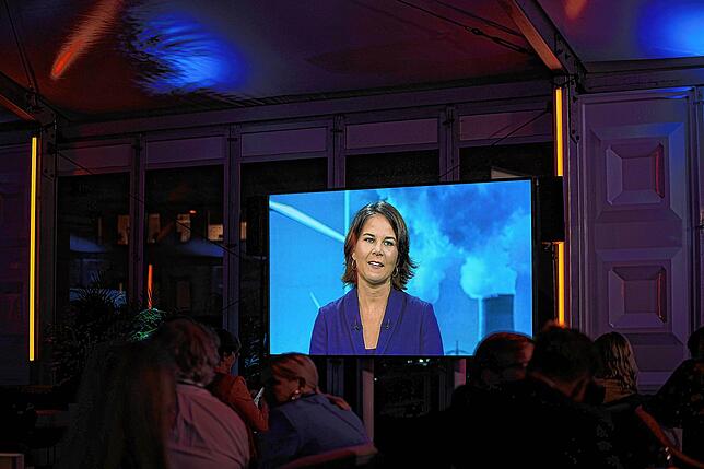 Annalena Baerbock (Bündnis 90/Die Grünen) erscheint während der Diskussion der Kandidaten auf einem Bildschirm in einem VIP Zelt.