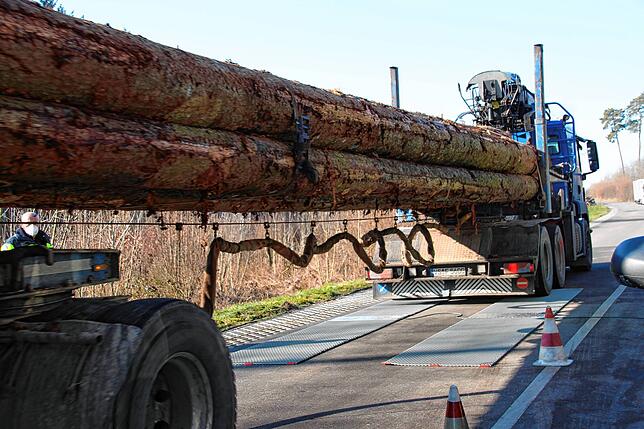 Der zuvor überladene Holztransporter muss nach dem Abladen erneut über die Überfahrwaage fahren.