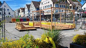 Mit bunten Pflanzenkisten, einem Sitzbereich, Liegestühlen und einem Sandkasten wertet die Stadt einen Teil der Trapp-Baustelle ...