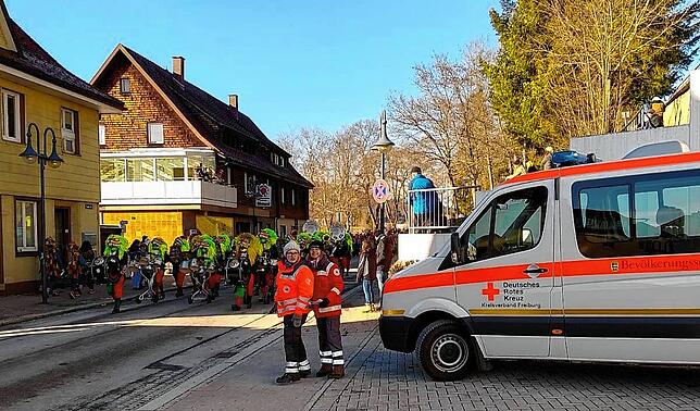 Rotkreuz-Mitarbeiter beobachten den Narrenumzug in Neustadt.