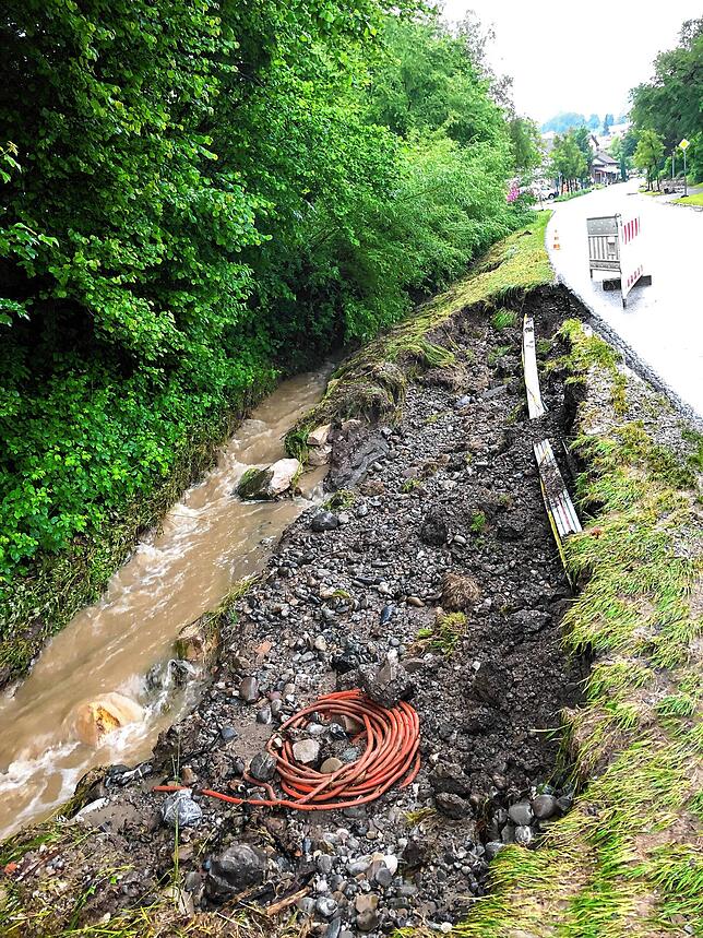 Ausgespülter Graben mit freigelegten Strom- und Glasfaserkabeln in der Schienerbergstraße