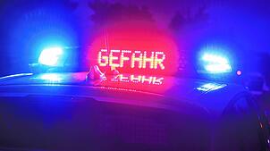 Ein Polizeifahrzeug mit Blaulicht und der Anzeige Gefahr (Symbolbild).