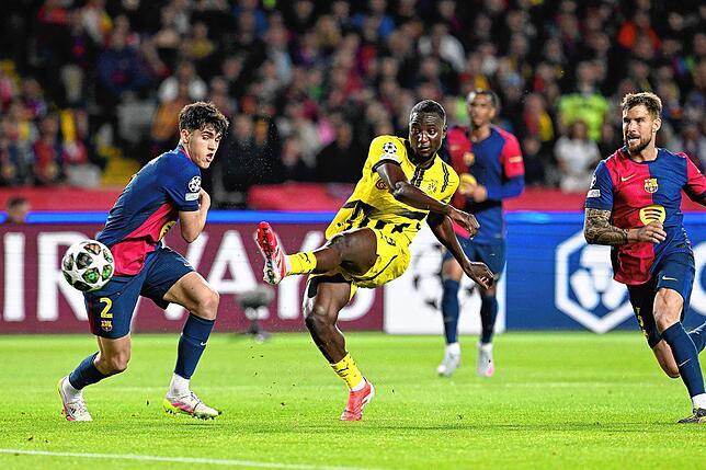 Serhou Guirassy (M) schießt neben Barcelonas Pau Cubarsi (l) auf das Tor.
