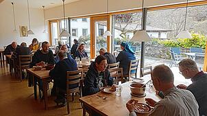 Brüder und Schwestern sitzen im Refektorium – dem Speisesaal – des Haupthauses zum gemeinsamen Mittagessen zusammen.