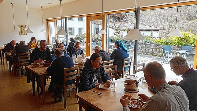 Brüder und Schwestern sitzen im Refektorium – dem Speisesaal – des Haupthauses zum gemeinsamen Mittagessen zusammen.
