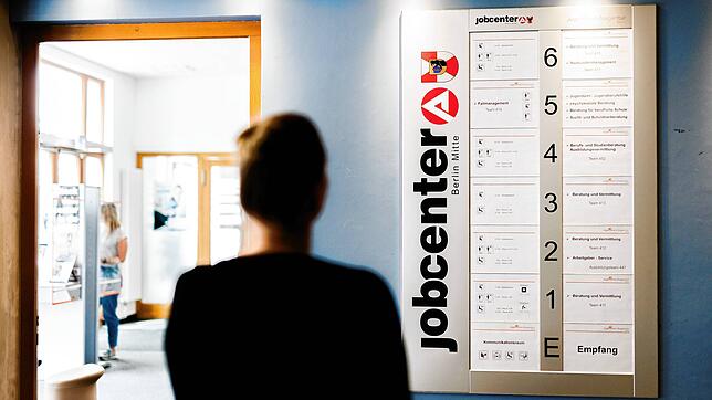 Eine Frau steht vor einer Informationstafel im Eingangsbereich einer Berufsagentur. (Symbolbild) Die Arbeitsagentur meldet im jüngsten ...