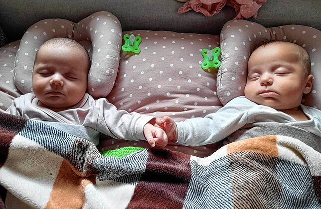 Träumt süß! Die Zwillinge schlafen im Stillkissen – Nele und Emma halten sich dabei an den Händchen fest.
