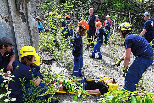 Ein geschminktes Feuerwehrmitglied als Verletzter wird bei der Übung aus einer schwierigen Lage geborgen.